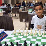 Six-year-old Whitby chess prodigy Srihan Raghunathan sits behind a chessboard while preparing to represent Canada at the world championship in Spain.