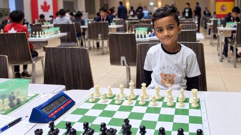 Six-year-old Whitby chess prodigy Srihan Raghunathan sits behind a chessboard while preparing to represent Canada at the world championship in Spain.